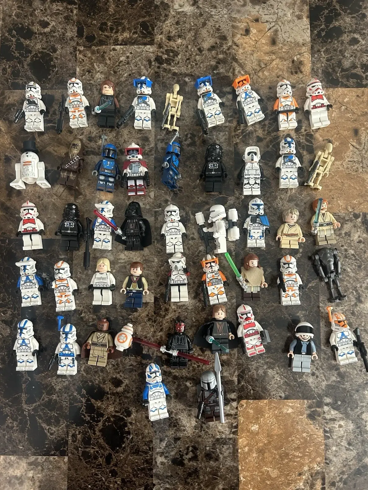 A lot of 47 Star Wars LEGO minifigures laid out on a counter