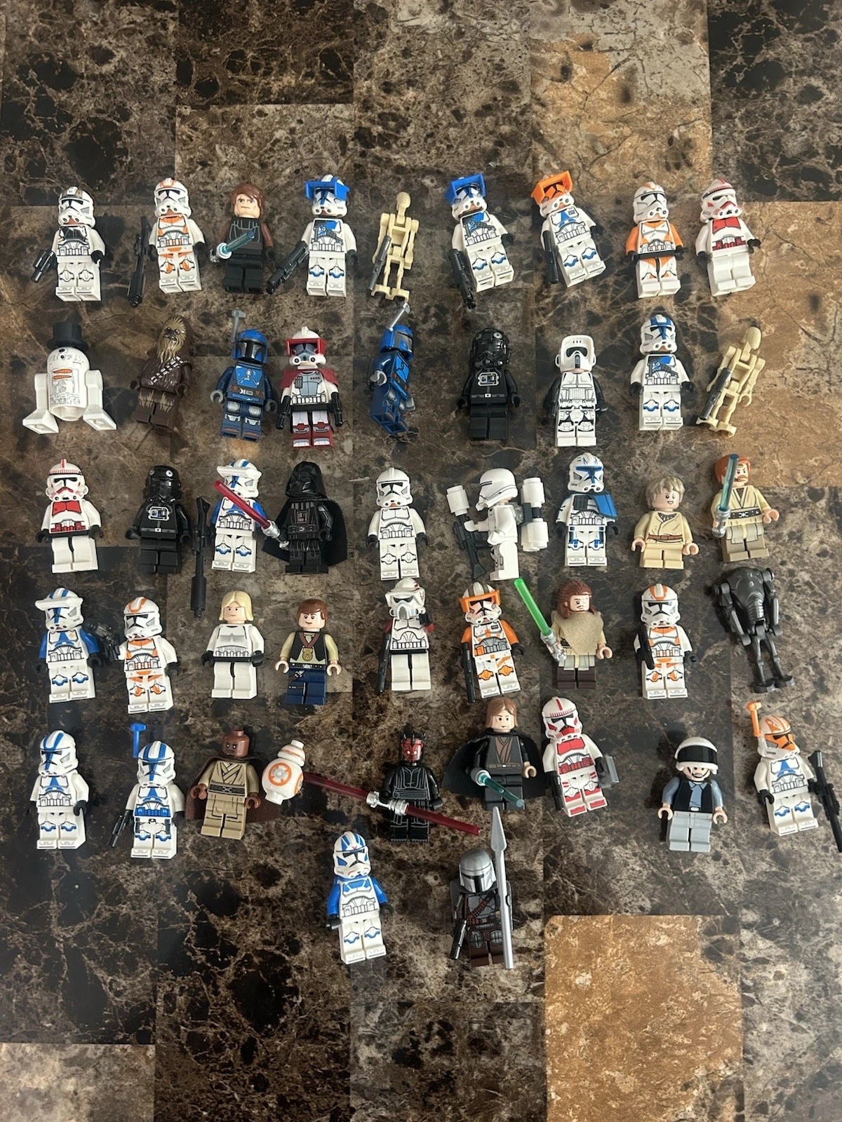 A lot of 47 Star Wars LEGO minifigures laid out on a counter